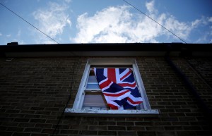 A British flag flutters in front of a window in London,